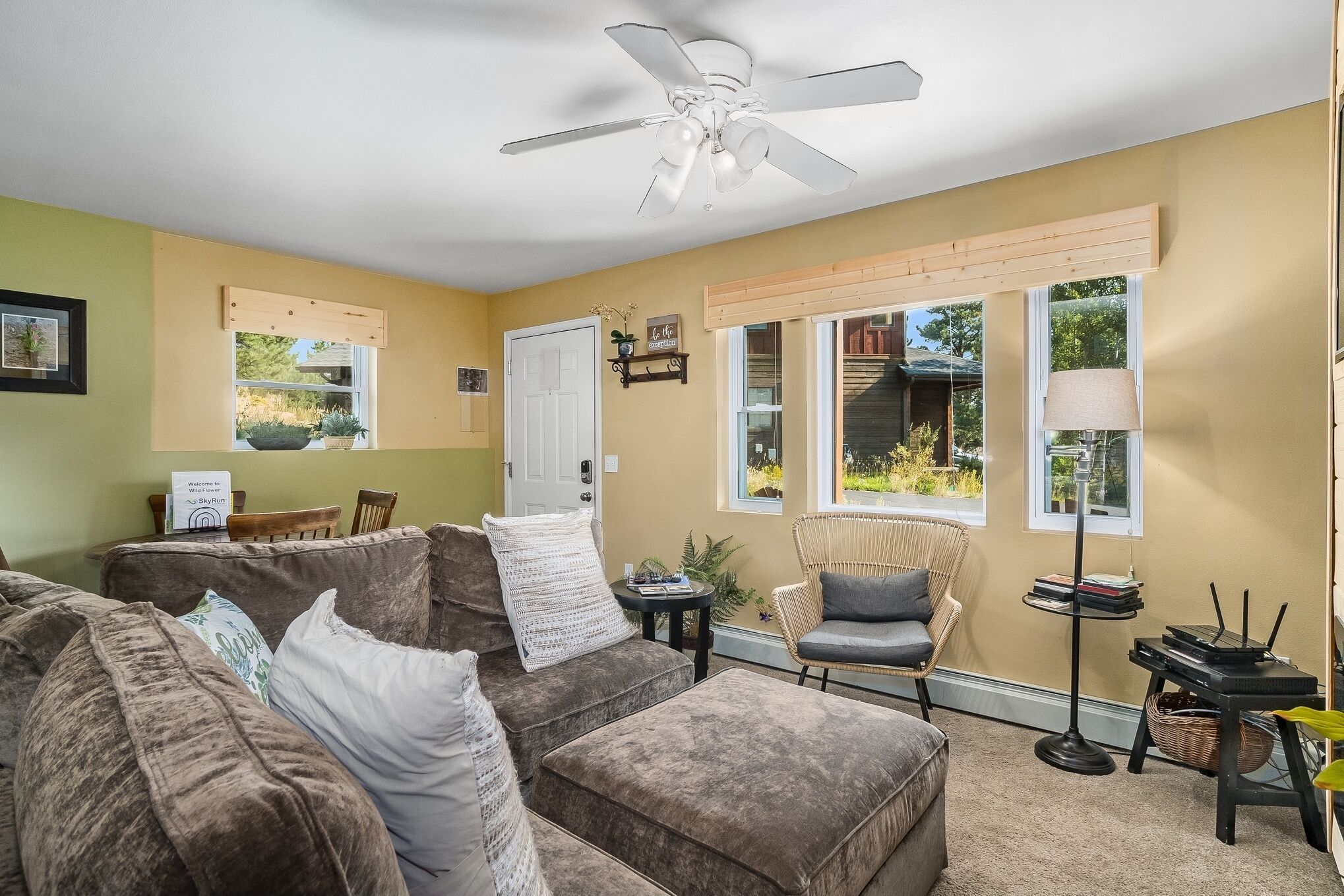 A living room with a ceiling fan, a sofa set, a chair, a small table, and a lamp.
