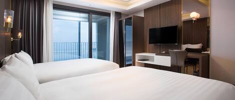 A hotel room with two beds, a desk, a chair, a TV, and a balcony with curtains.