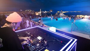 A DJ booth with a poolside view overlooking a cityscape at night. - Utop Marina Hotel & Resort (Yeosu)