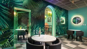 A restaurant with a tropical theme, featuring green walls, palm leaf patterns, and a checkered floor. - Utop Marina Hotel & Resort (Yeosu)