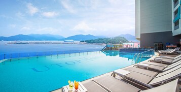 Una piscina al aire libre de temporada, sillones reclinables de piscina