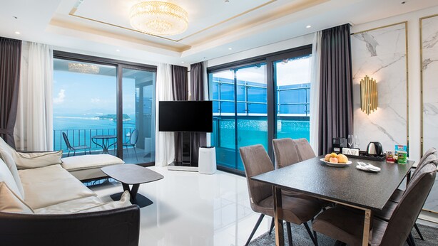 A modern hotel room with a balcony, a dining area, and a TV. - Utop Marina Hotel & Resort (Yeosu)