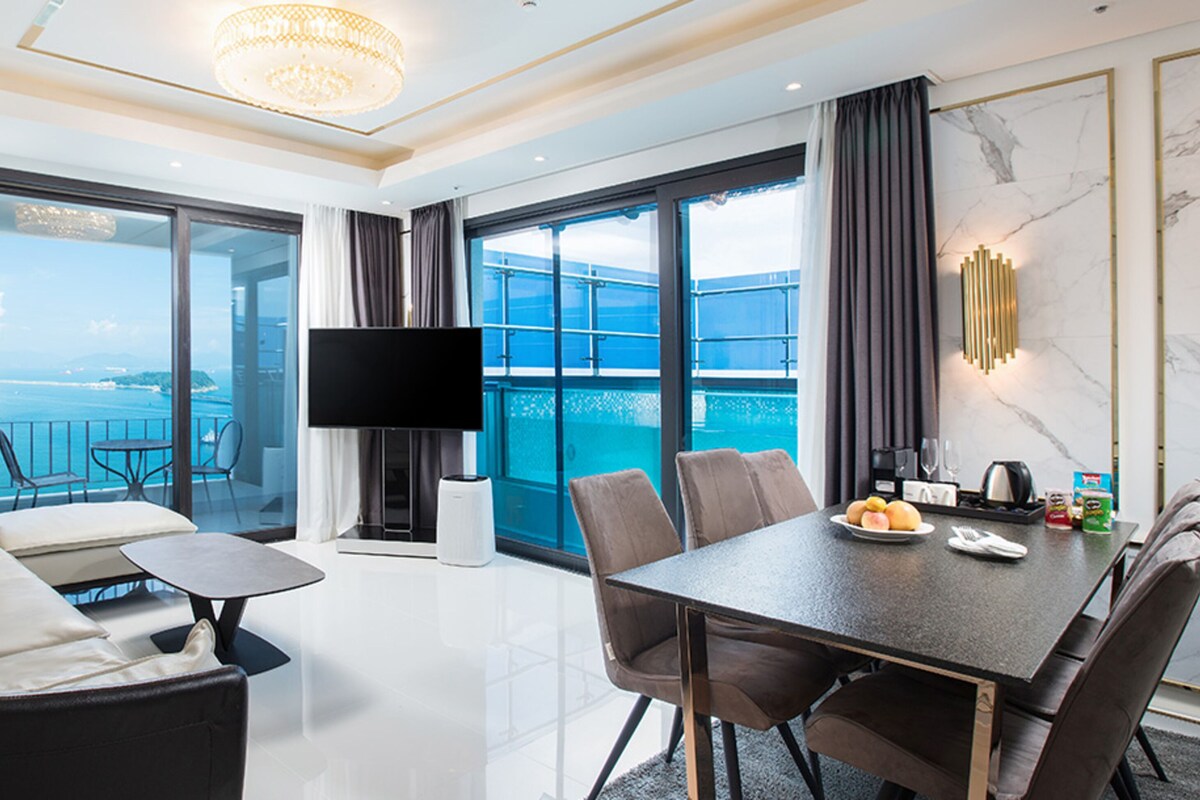 Una habitación de hotel moderna con balcón, comedor y televisor.