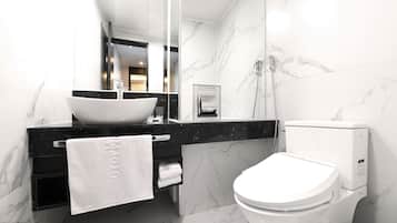 Un baño moderno con un lavabo blanco, encimera negra y un inodoro.