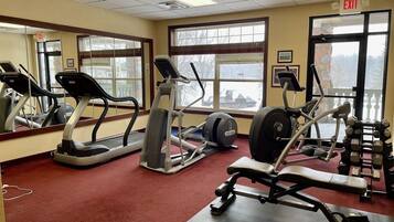 A gym with treadmills, elliptical machines, and weight benches.
