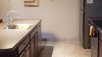 A kitchen with a large island, stainless steel appliances, and a decorative wall piece.