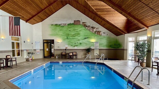 An indoor swimming pool with a wooden ceiling, a mural of a landscape, and a flag. - Unit 312 1 Bd/ 1 Ba Condo 1 Bedroom Condo by RedAwning (Birchwood)