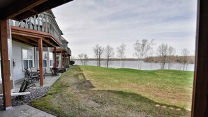 A lakeside property with a covered patio, outdoor seating, and a view of the lake. - Unit 312 1 Bd/ 1 Ba Condo 1 Bedroom Condo by RedAwning (Birchwood)