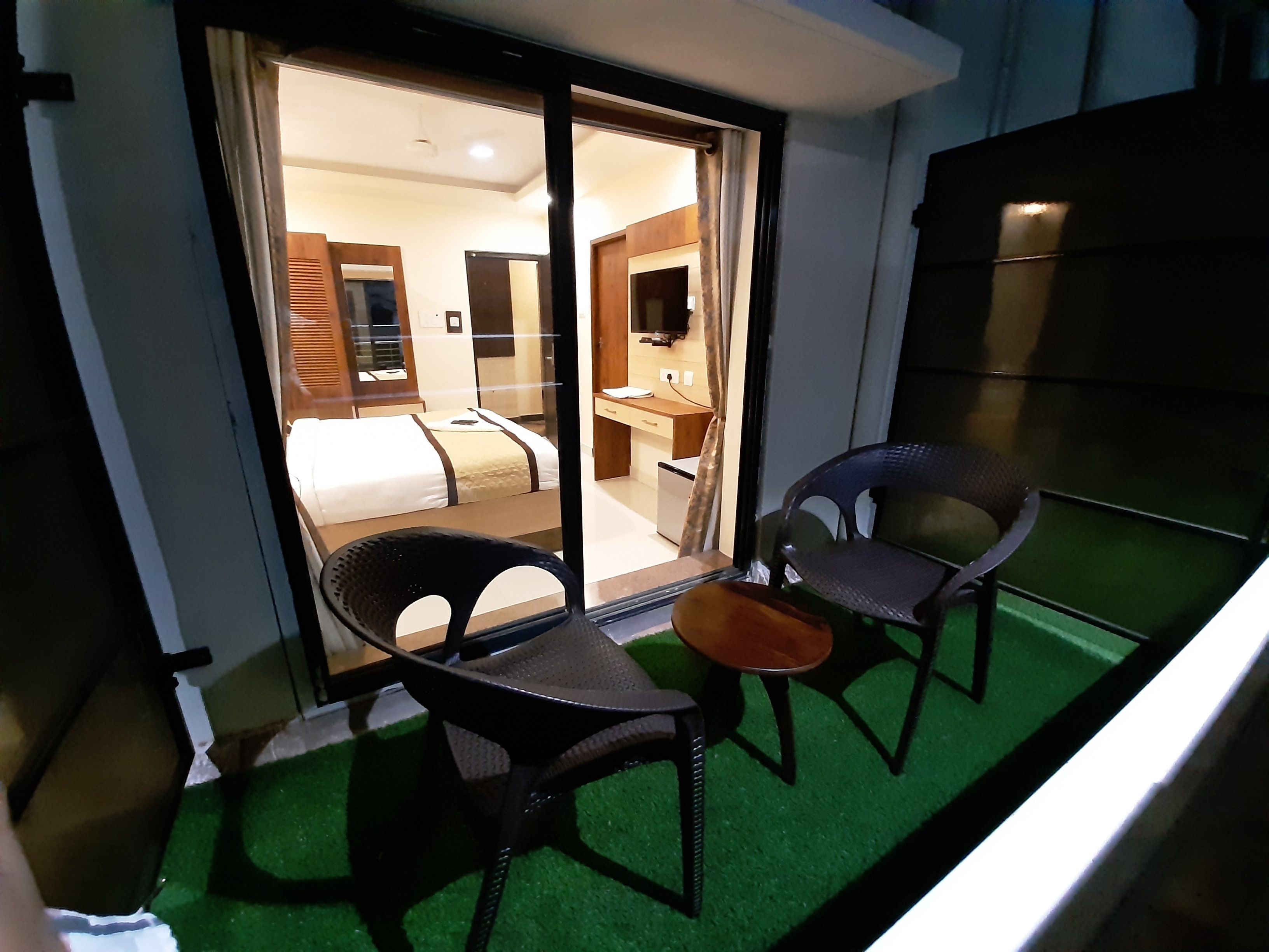 A hotel room with a bed, a desk, and two chairs.