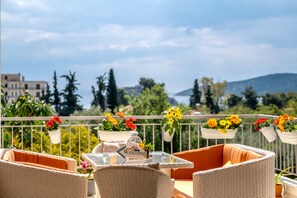 Un balcone con mobili in vimini, fioriere e un cartello di benvenuto.