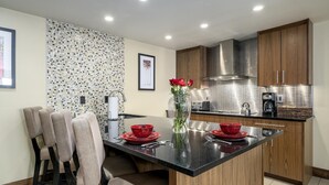 Een moderne keuken met een centraal eiland, houten kasten en een betegelde spatwand.