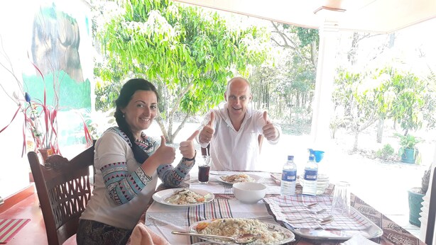 Una mesa de comedor con platos de comida, botellas de agua y un tazón de arroz.
