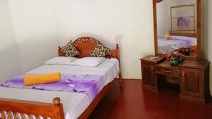 Un dormitorio ordenado con una cama de madera, una mesita de noche, un espejo y un pequeño escritorio.
