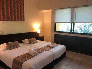 Relax in comfort with a large bed, nightstand, and lamp.