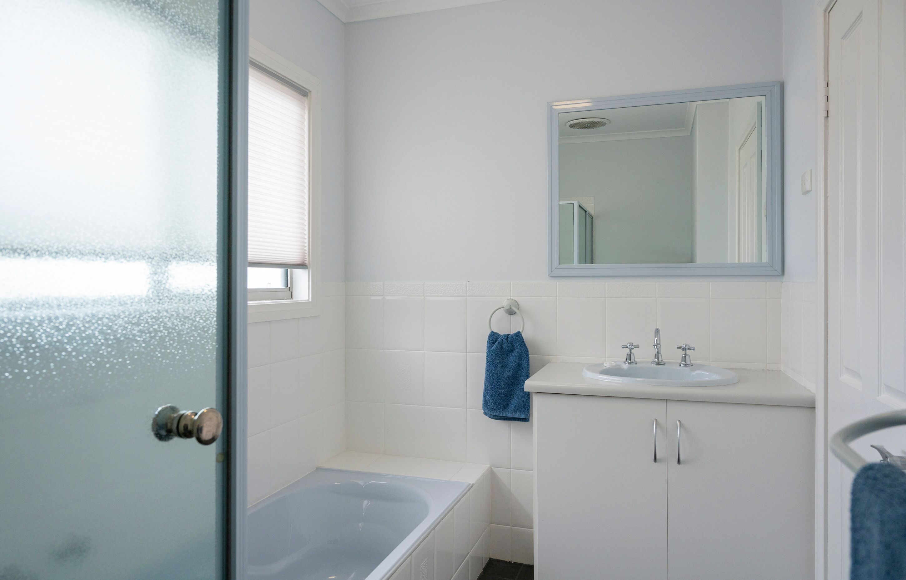 A bathroom with a bathtub, a sink, and a mirror.