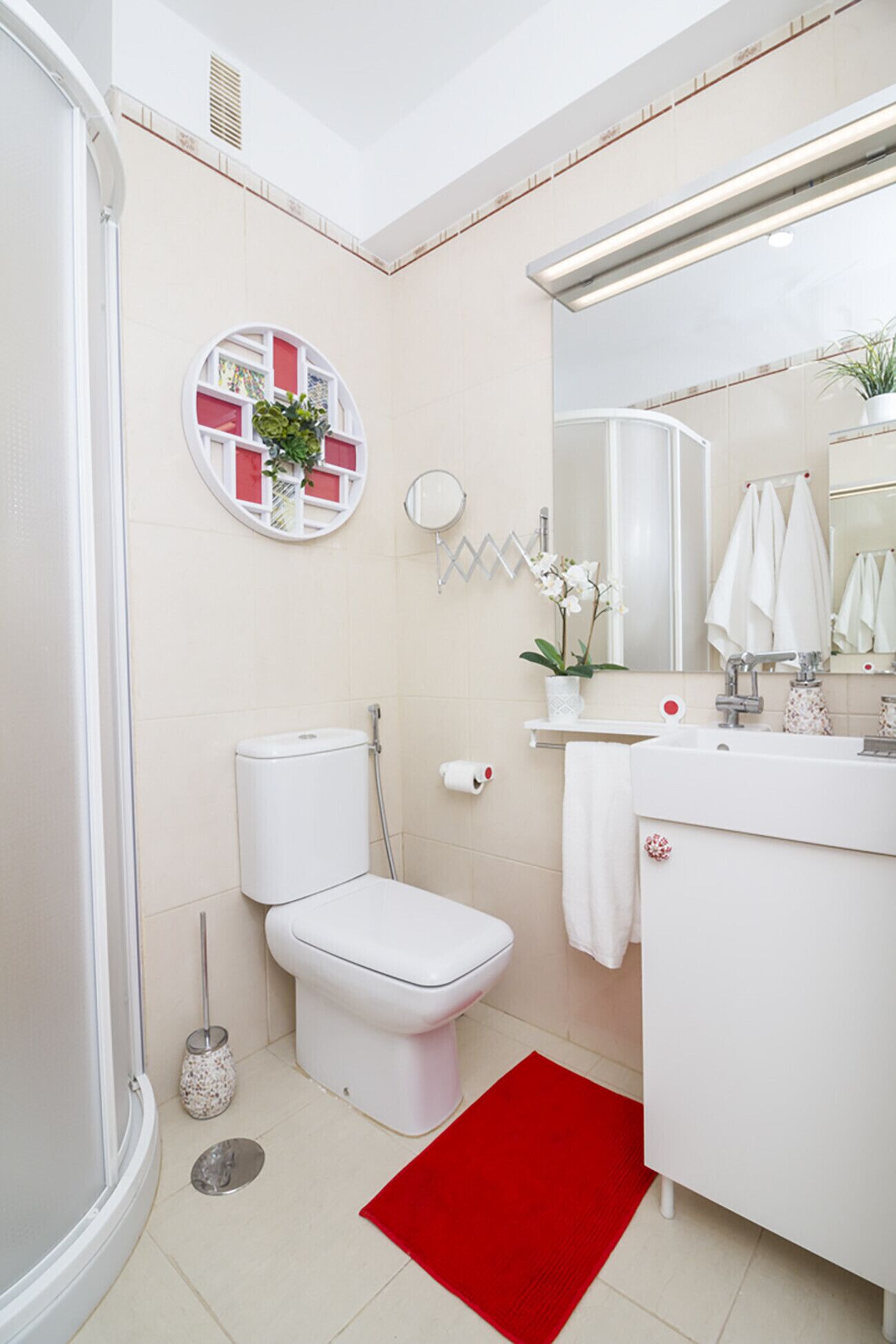 Et moderne badeværelse med toilet, vask, spejl og bruser.