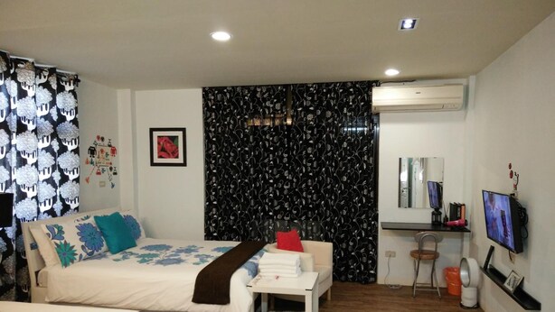A hotel room with two beds, a desk, a TV, and a mirror. - Jia Mei Fa Homestay (Taitung)