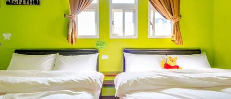 A room with two beds, a window with curtains, a picture on the wall, and a Winnie the Pooh pillow.