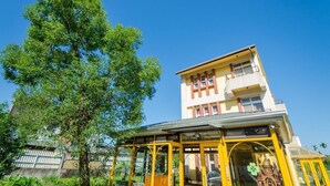 A two-story building with a yellow facade and a covered entrance area. - Sunshine House (Dongshan)