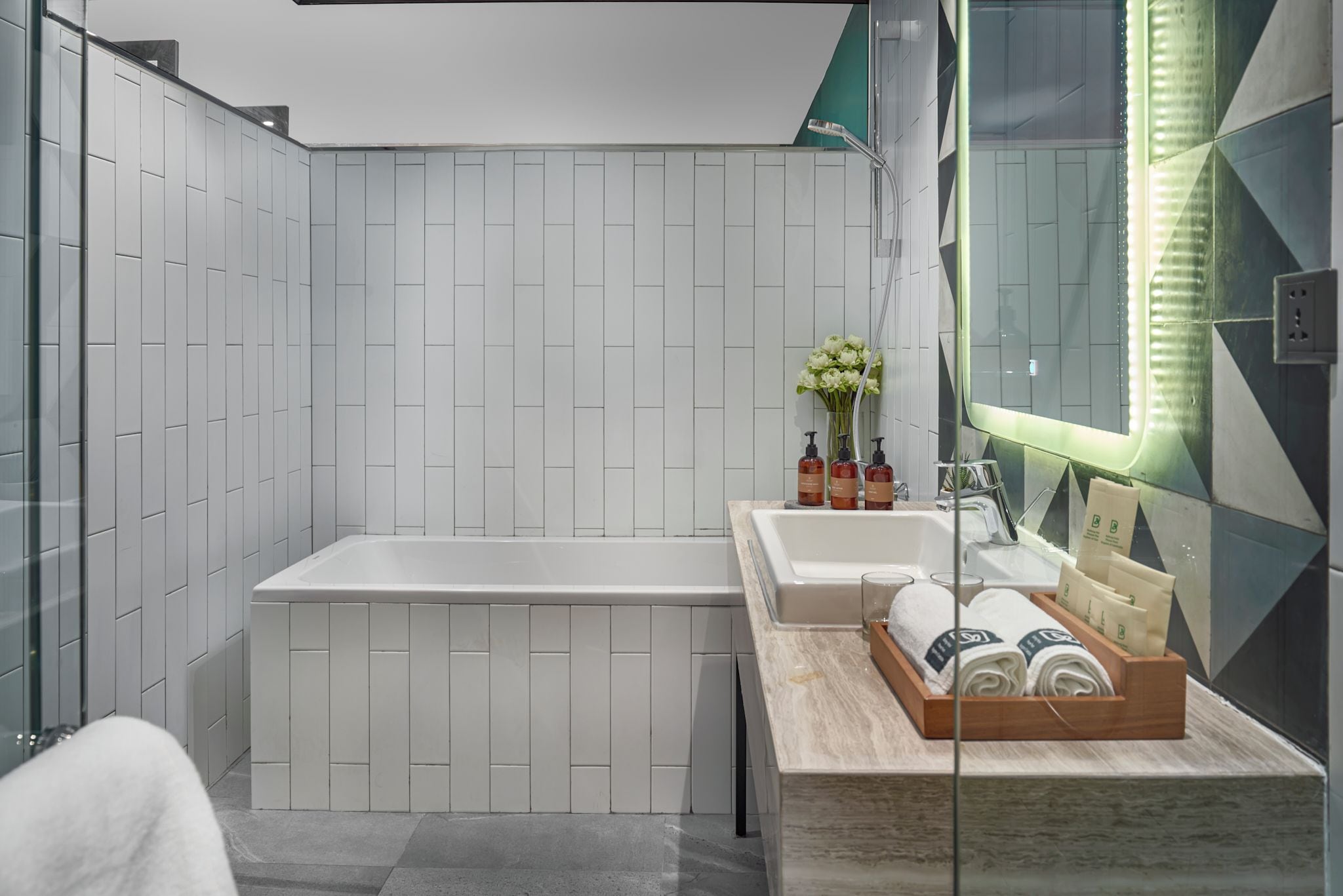 A modern bathroom with a large bathtub, a vanity with a mirror, and a shower area.