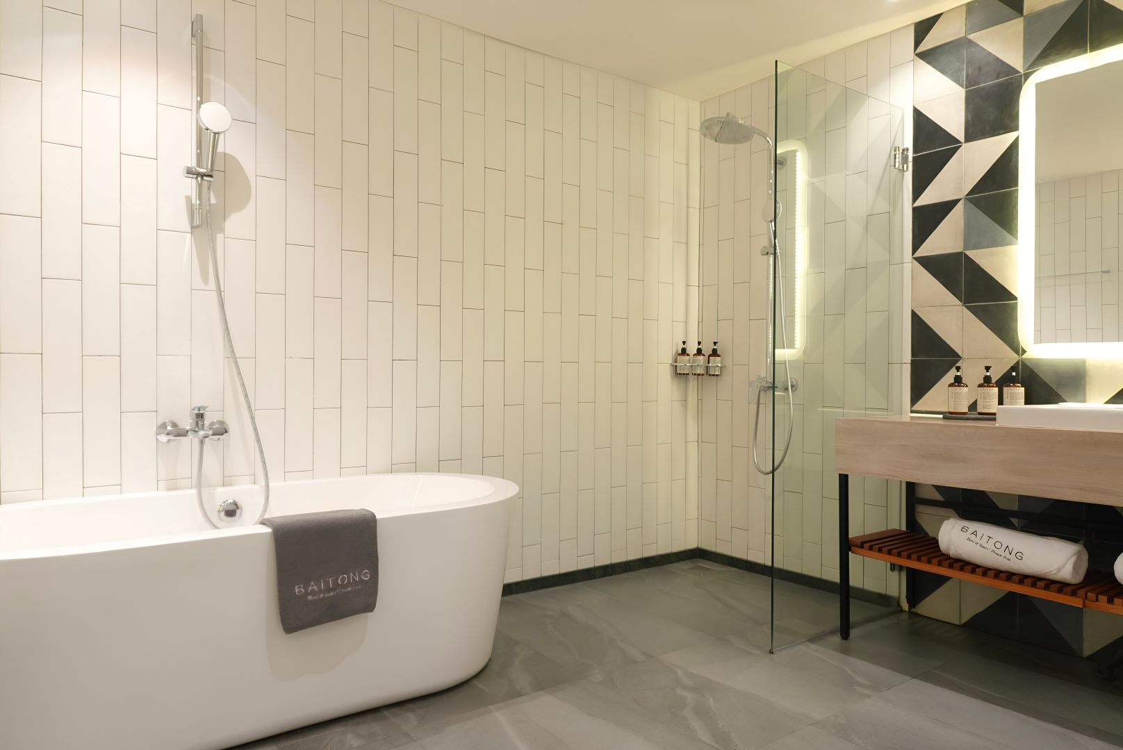 A modern bathroom with a freestanding bathtub, a glass-enclosed shower, and a vanity with a mirror and toiletries.