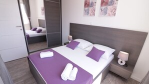 Une chambre moderne avec un grand lit, une table de chevet avec une lampe et un miroir.