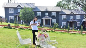 A house with a garden and outdoor seating. - MiCO Hill Resort (Pyin Oo Lwin)