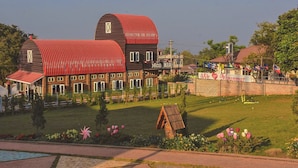 A large, two-story building with a red roof and a sign that reads "Mico Myanmar." - MiCO Hill Resort (Pyin Oo Lwin)
