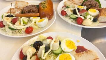 A buffet with various dishes including salads, meats, and rice.