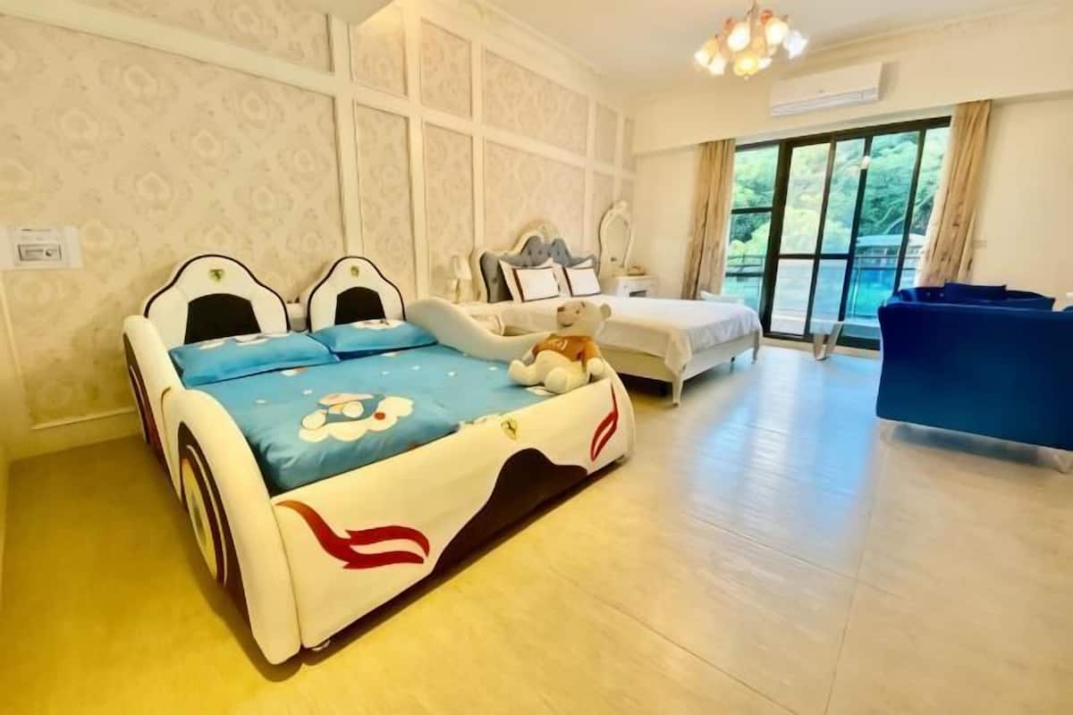 Ein Schlafzimmer mit einem Bett, einem Schlafsofa, einem Sessel und einem großen Fenster.