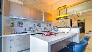 Una cocina moderna con una isla central, taburetes de bar y una máquina de café.