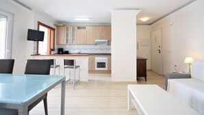 Un appartement moderne comprenant un coin repas, une cuisine et un espace de vie.