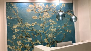 A reception desk with a blue wall featuring a floral mural.