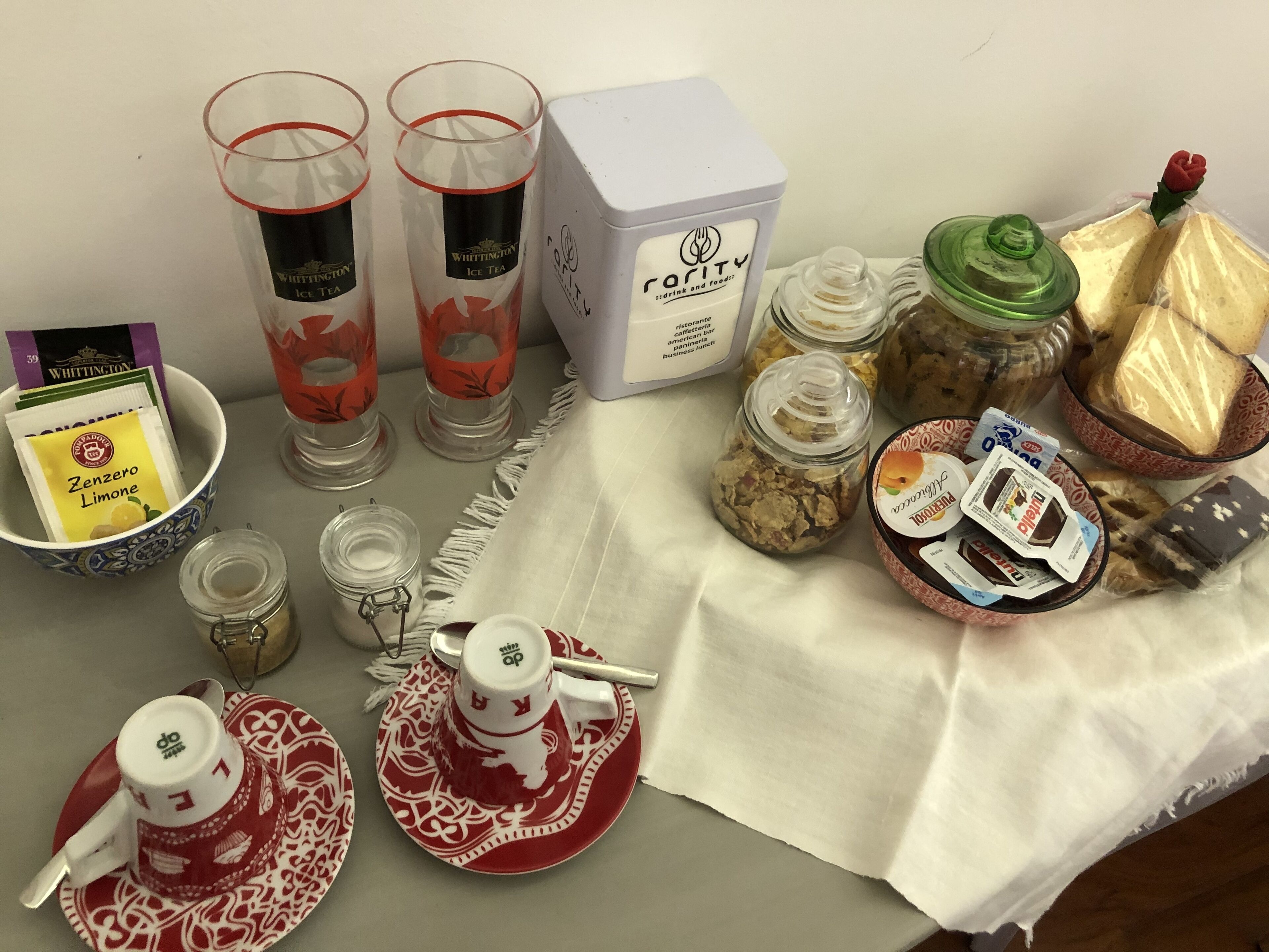 Ein Tisch mit Teegläsern, einer mit 'rarity' beschrifteten Schachtel, Lebensmitteldosen und einer Platte mit Teekanne und Tassen.