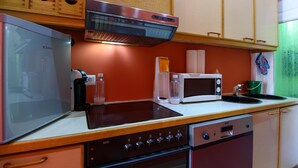 A compact kitchen with a microwave, toaster, and stove.