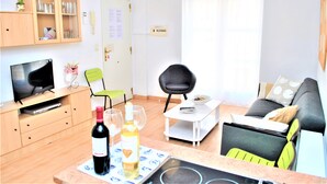 Een knus verblijf met een televisie, een eettafel, een bank en een kitchenette.
