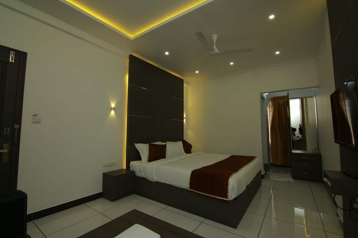 A modern bedroom with a large bed, bedside tables, a ceiling fan, and a mirror.