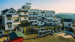 A multi-story hotel with a prominent sign reading "PALETTE RESORT". - Palette Hill View Resort Vagamon (Peermade)
