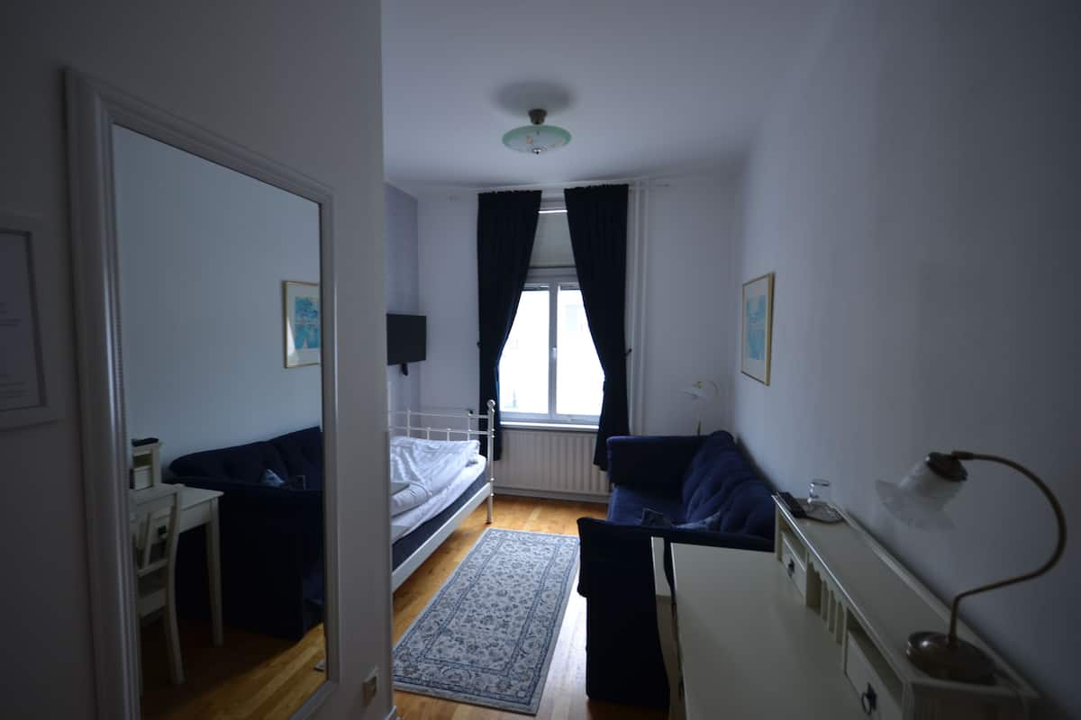 A compact room with a bunk bed, a desk, and a chair.