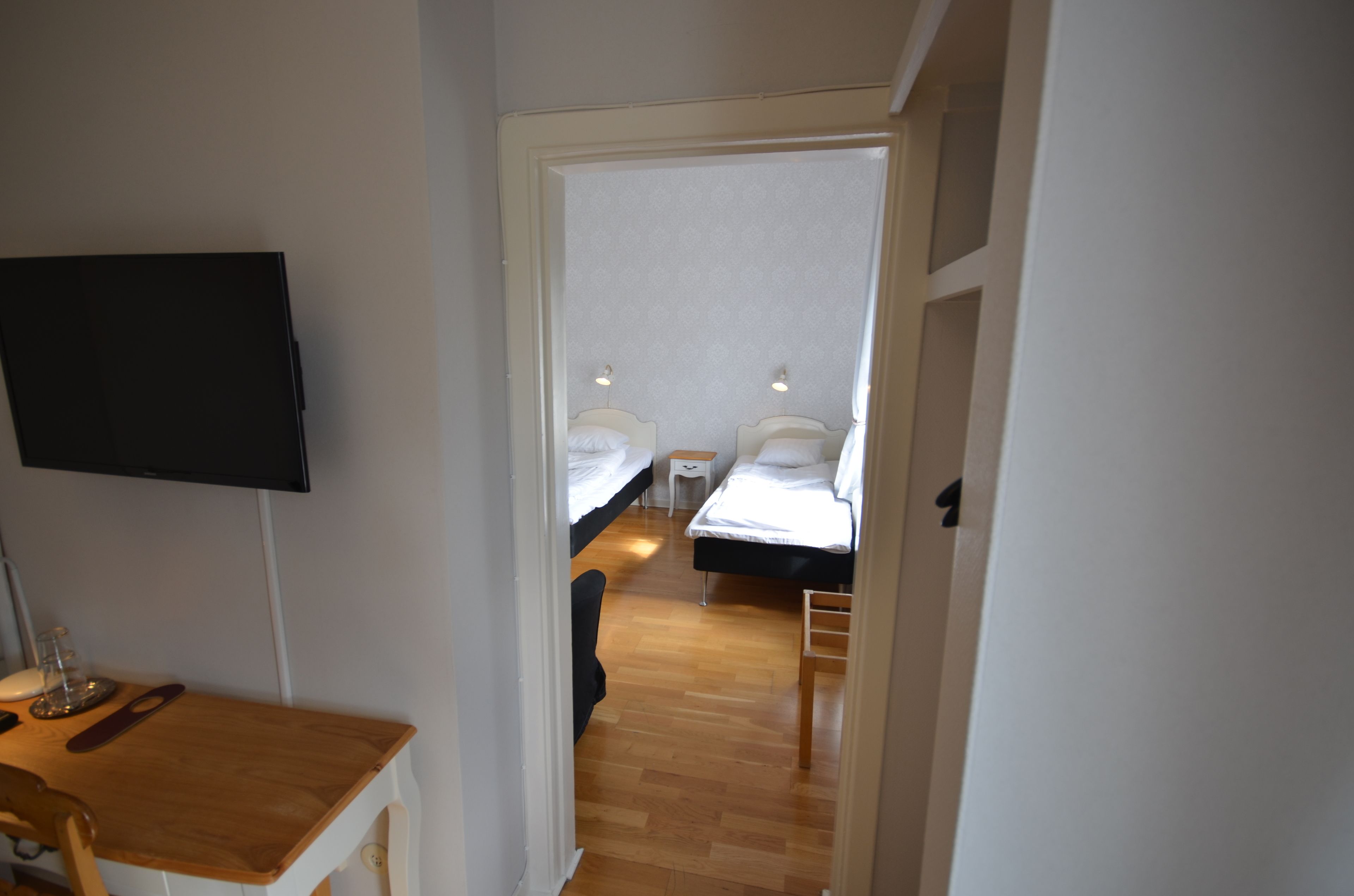 A room with two beds, a desk, and a TV.