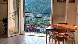A room with a balcony, a dining table, and chairs. - Sofia and Oscar's house Lake Como Canzo (Canzo)