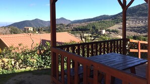 A wooden balcony with a view of a vineyard and mountains. - Serra de Prades Resort - Campsite (Vilanova de Prades)