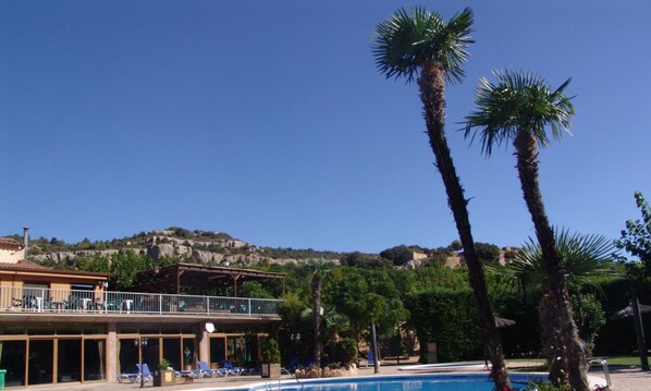 Piscine extérieure en saison, parasols, chaises longues