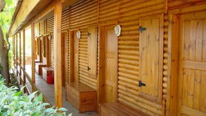 A wooden cabin with log walls, a covered porch, and a bench. - Serra de Prades Resort - Campsite (Vilanova de Prades)