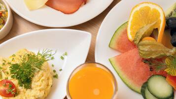 Desayuno con platos de huevos, jamón, queso y pan.