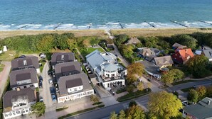 Vista aérea de una zona residencial costera con casas, una carretera y una playa.