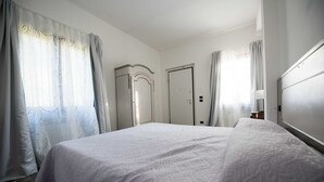 Ein Schlafzimmer mit Bett, Kleiderschrank und Tür.