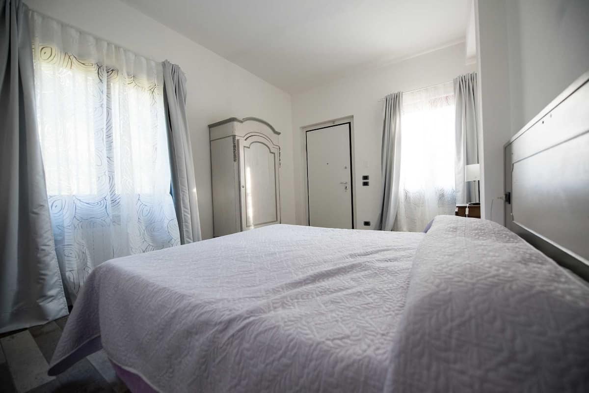 A bedroom with a bed, a wardrobe, and a door.