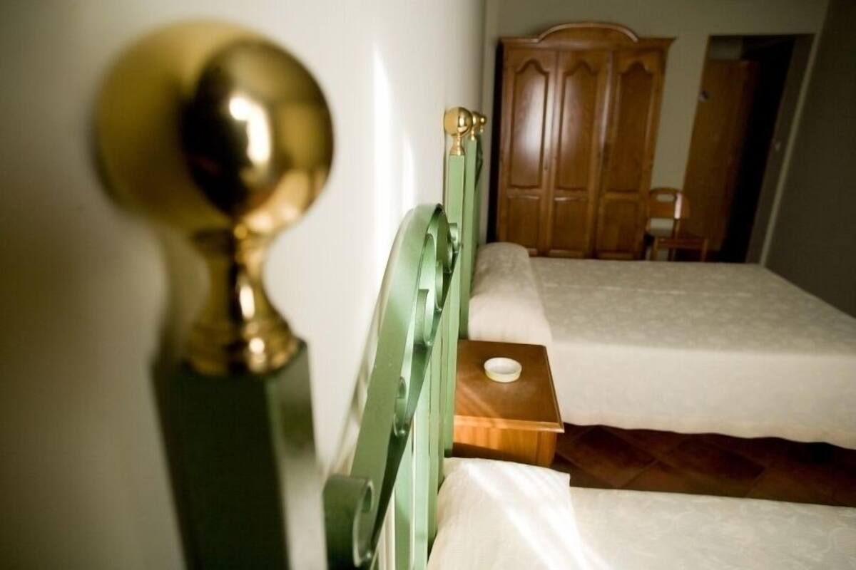 Un dormitorio con una cama, un armario de madera y un llamador de bronce.