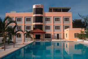 Ein Hotel mit Schwimmbad, mehreren Balkonen und einem zentralen Innenhof.